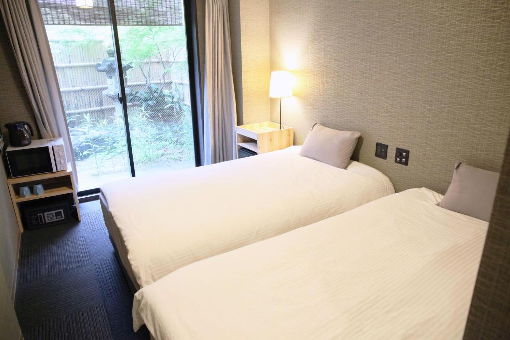 Postel nebo postele na pokoji v ubytování HOTEL LEGASTA KYOTO SHIRAKAWA SANJO