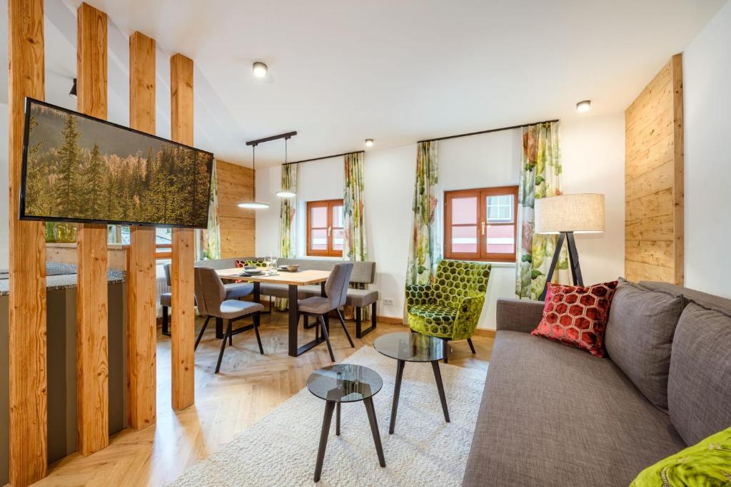 a living room with a couch and a table at Thorbäck Gut - Apartments im Schlosserhaus in Öblarn