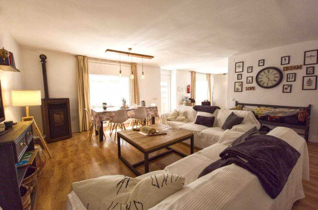 a living room with two white couches and a table at La Casita de Rosa - Sierra de Francia in Aldeanueva de la Sierra