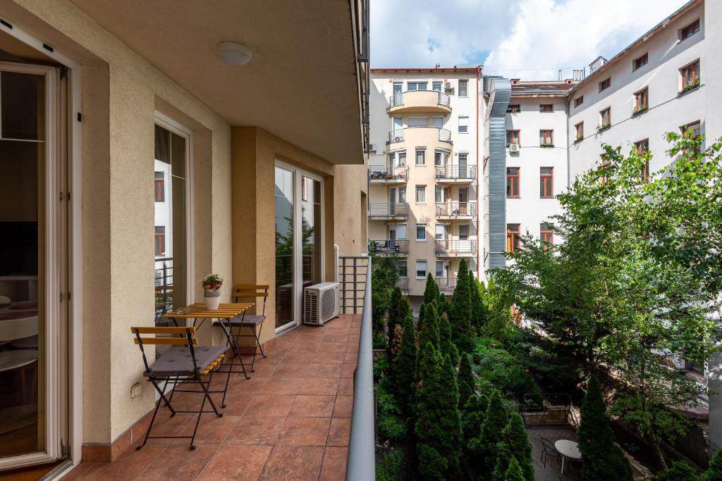 - un balcon avec des chaises, une table et des bâtiments dans l'établissement Pesti City Apartment&Free parking, à Budapest