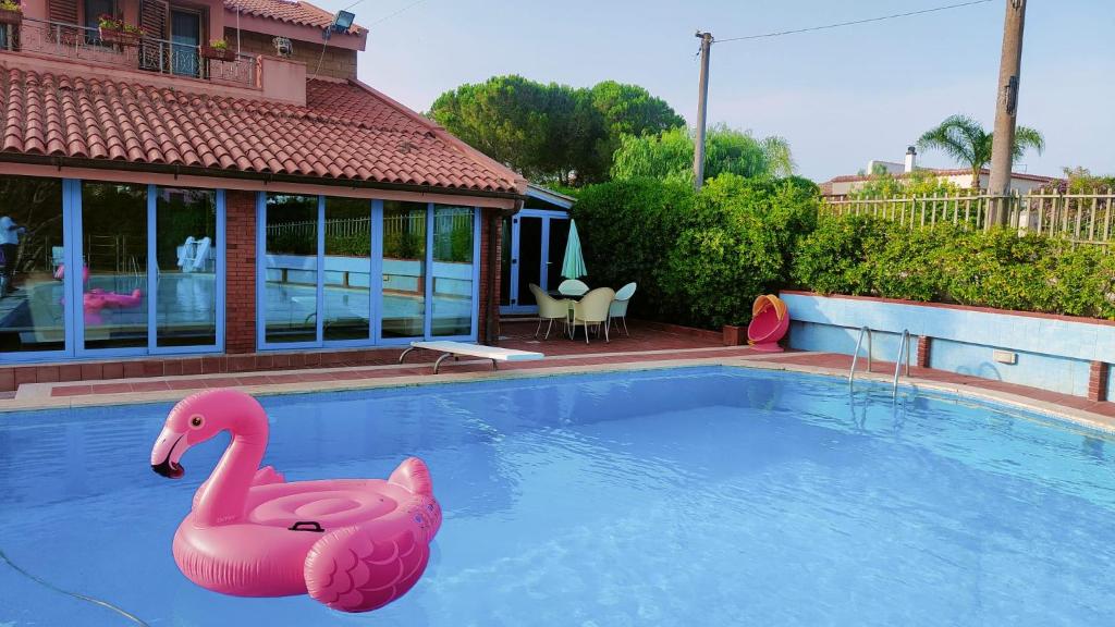 um cisne insuflável cor-de-rosa numa piscina em Villa Vella em Siracusa