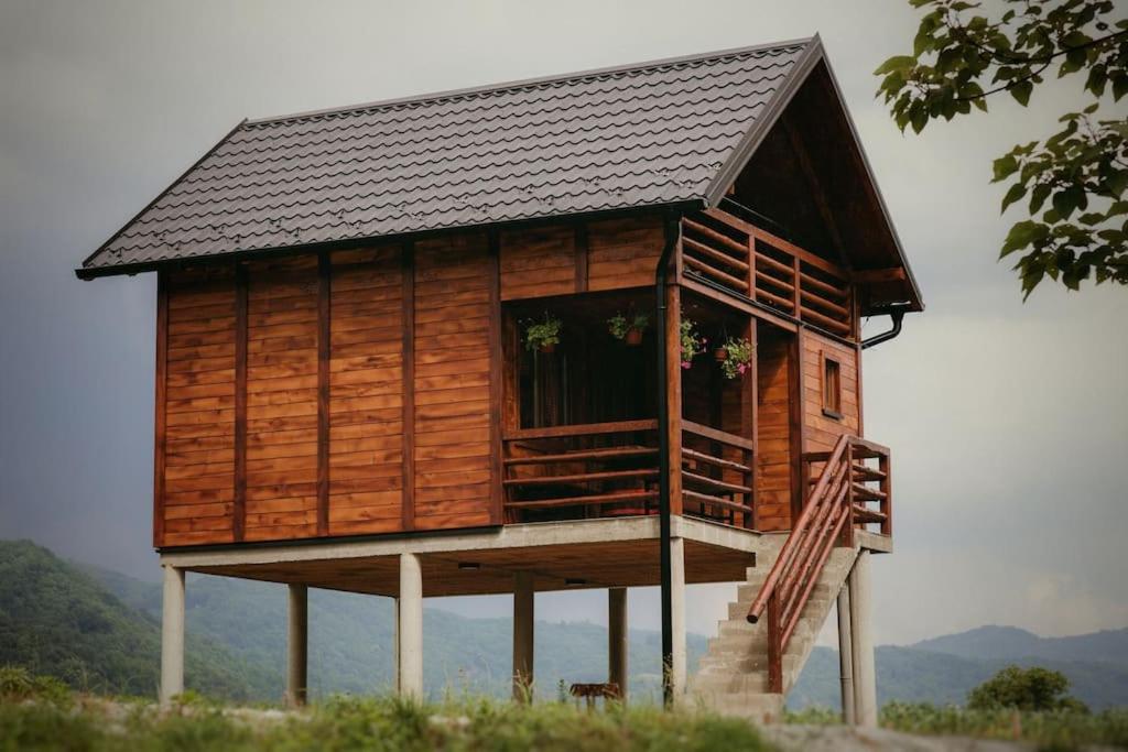 Etno Kutak Purtić في Ljubovija: منزل خشبي امامه درج