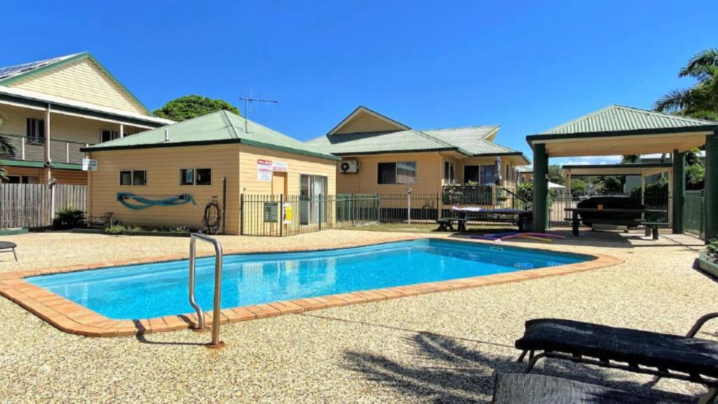 a swimming pool in front of a house at San Marco Villa Close To Beach in Burrum Heads