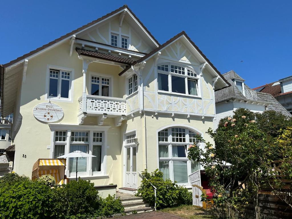 Una gran casa blanca con balcón. en Villa Pension Strandhaus - adults only, en Travemünde