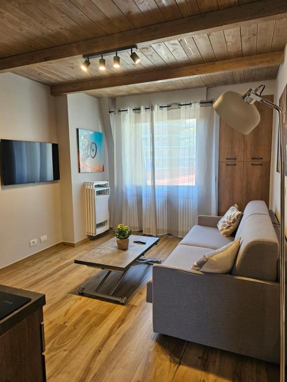 a living room with a couch and a television at Moda Apartments 69 in Sestriere