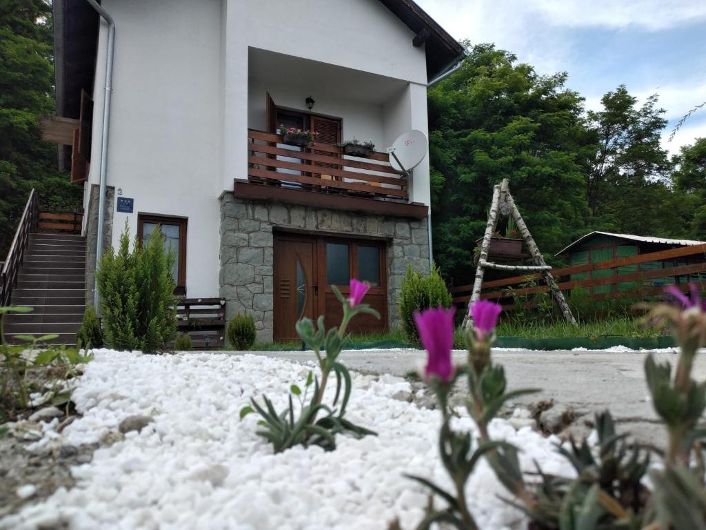 a house with a balcony and flowers in the snow at Holiday home Tilia in Slatinski Drenovac