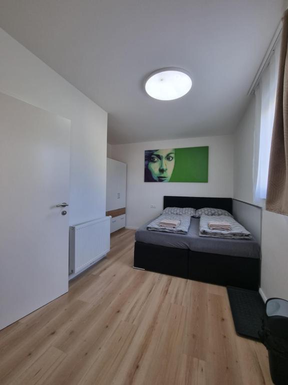 ein Schlafzimmer mit einem Bett und einem grünen Gemälde an der Wand in der Unterkunft RingRooms in Knittelfeld