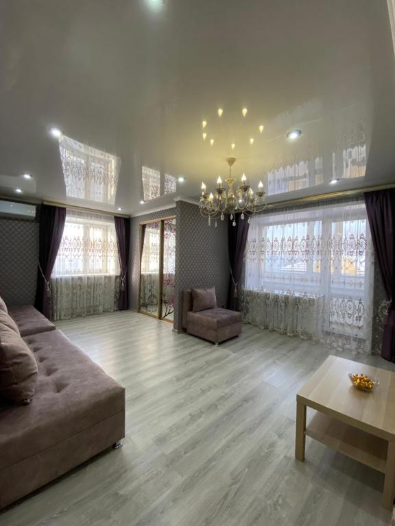 sala de estar con sofá y mesa en VIP квартира в Центре, 2 комнаты, en Kostanái