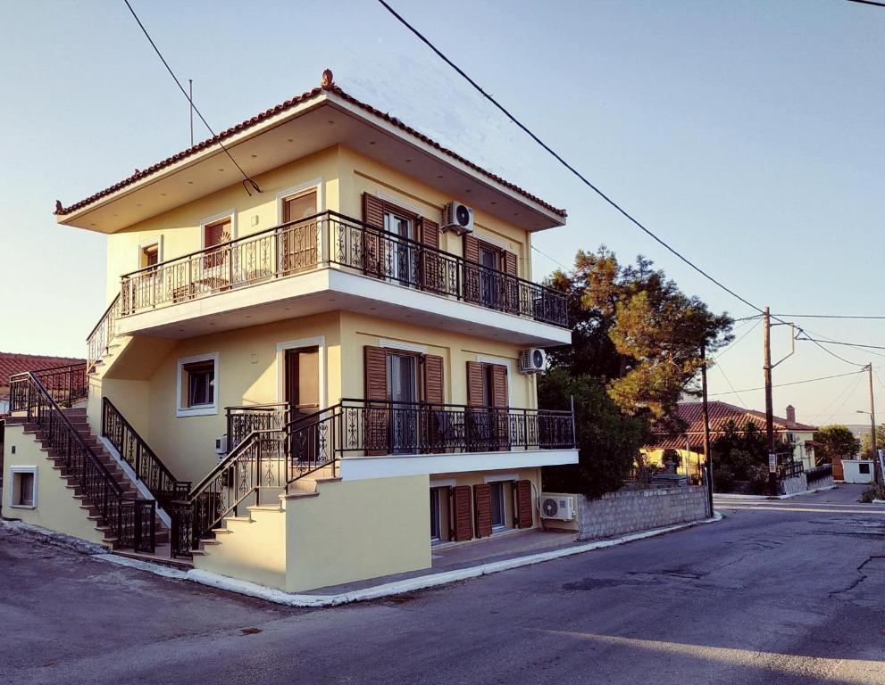 un edificio amarillo con balcones y escaleras en una calle en Central Moudros apartments, en Moúdhros