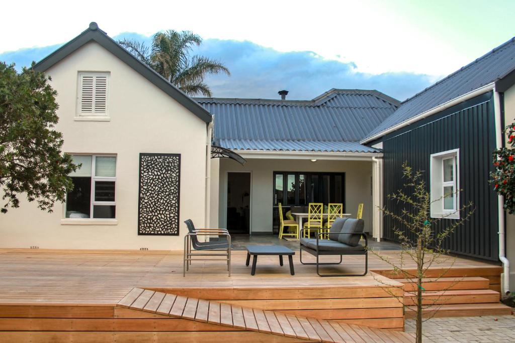 a house with a patio with a table and chairs at Hermanus Champagne Accommodation in Hermanus