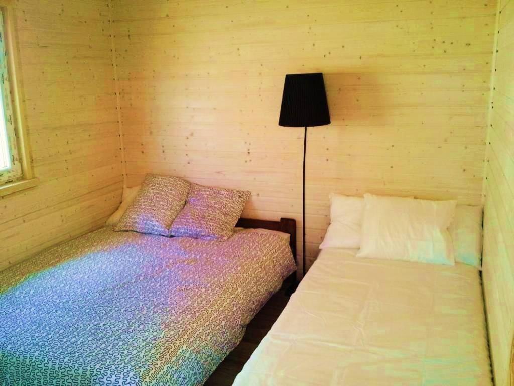 a bedroom with two beds and a lamp in it at Morskie Siedlisko Jarosławiec in Jarosławiec
