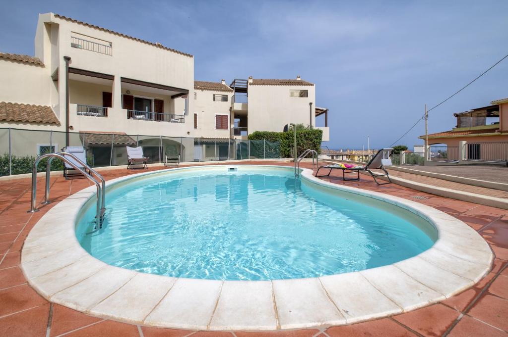 a swimming pool in the middle of a brick patio at Soleluna apartment in Castelsardo