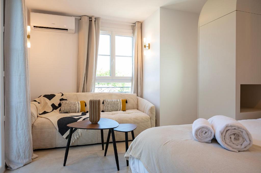 a living room with a couch and a table at Superbe studio avec balcon vue mer à 100m de la plage in Saint-Tropez
