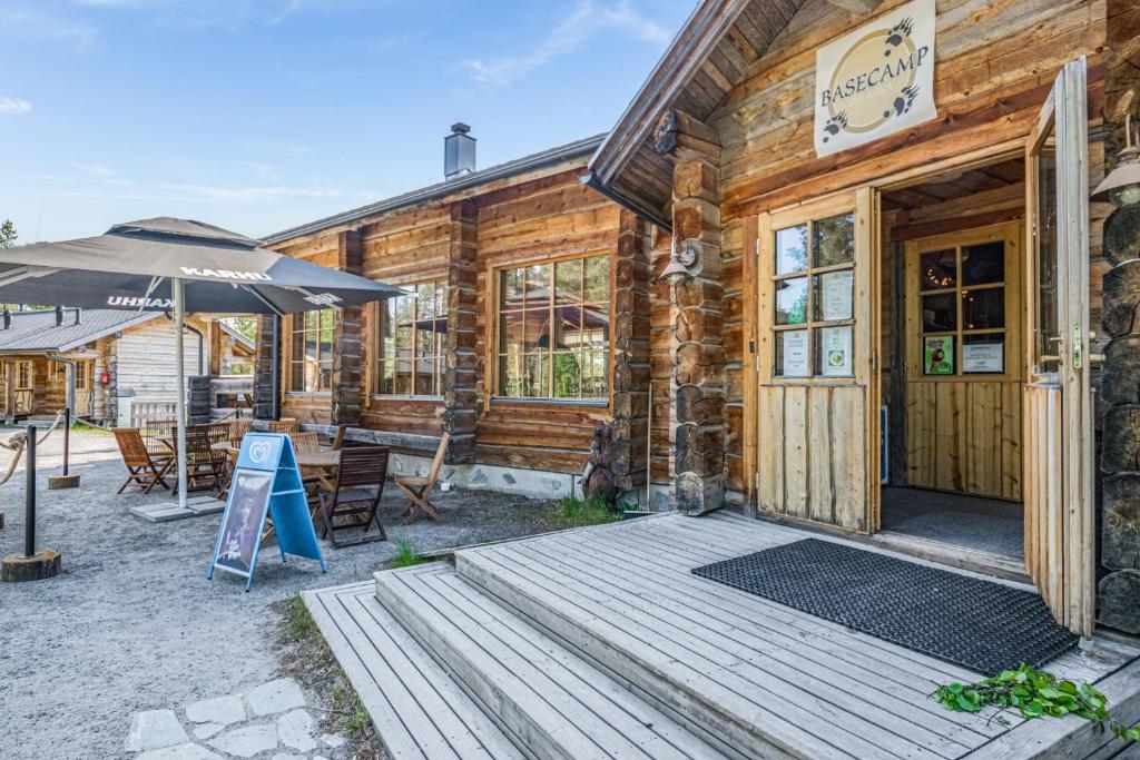 a wooden cabin with an open door and an umbrella at Basecamp Oulanka in Ruka
