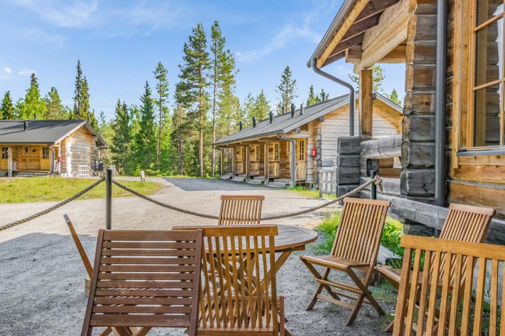 una mesa y sillas en el porche de una cabaña de madera en Basecamp Oulanka, en Ruka