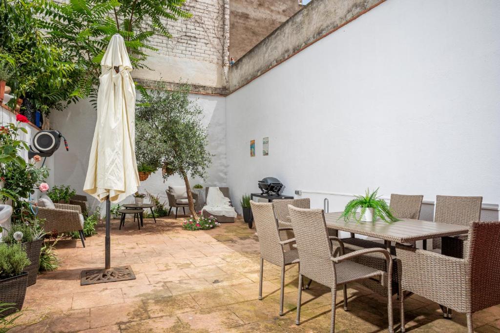 un patio con mesa, sillas y sombrilla en Carme -Alojamiento céntrico en Girona, en Girona