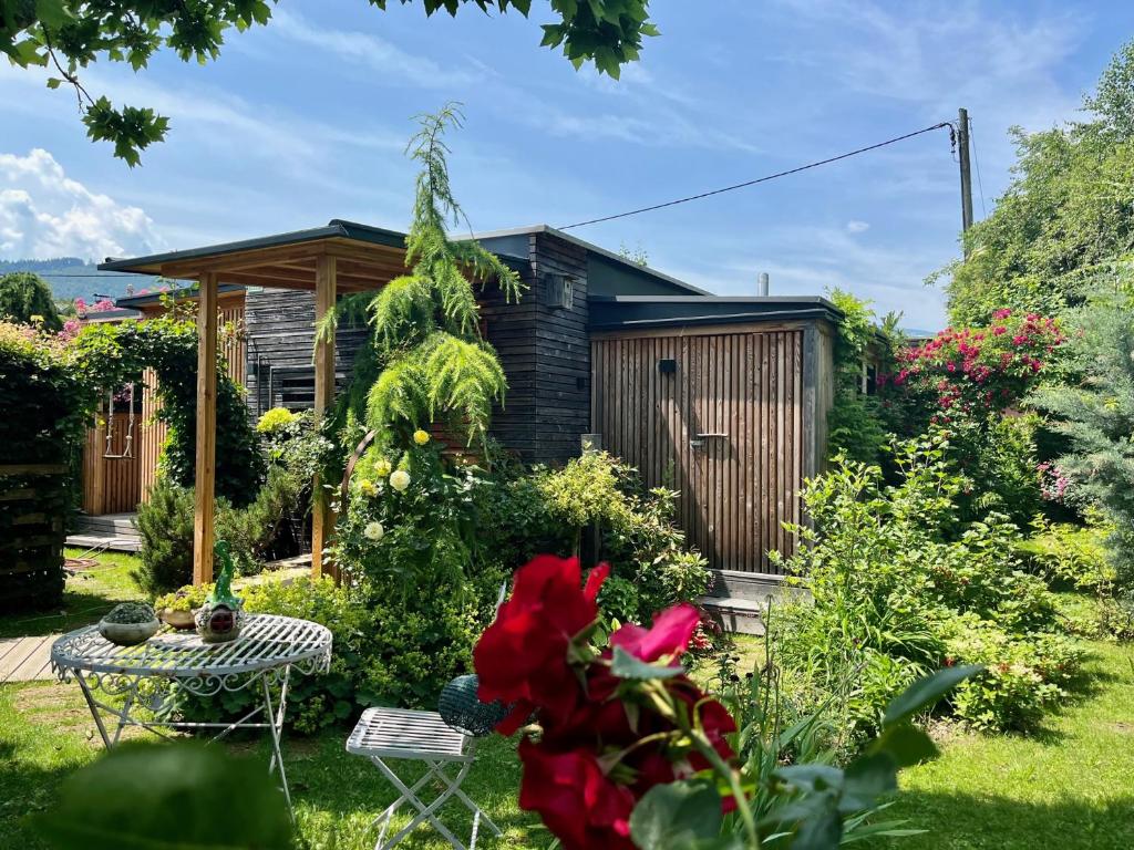 un jardín con una pequeña casa con una mesa en My Tiny Moos - Exklusiver Urlaub im Tiny House en Annenheim