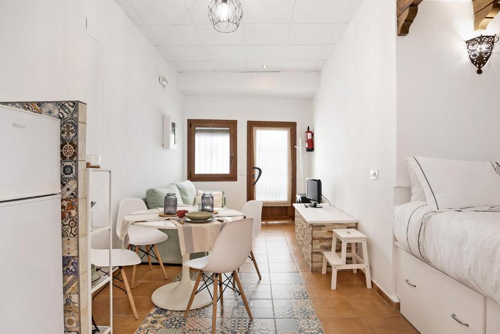 a white room with a dining table and a bed at Casa de Berta in Vejer de la Frontera