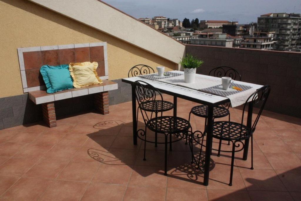 einen Tisch und Stühle auf dem Balkon in der Unterkunft Casaci in Acireale