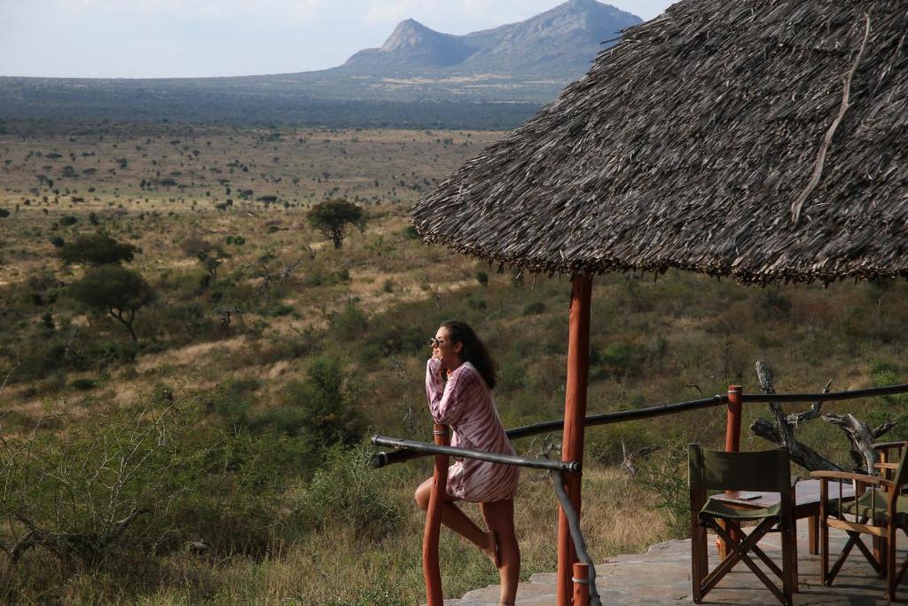 a woman in a dress is talking on a cell phone at Soroi Leopards Lair in Mwatate