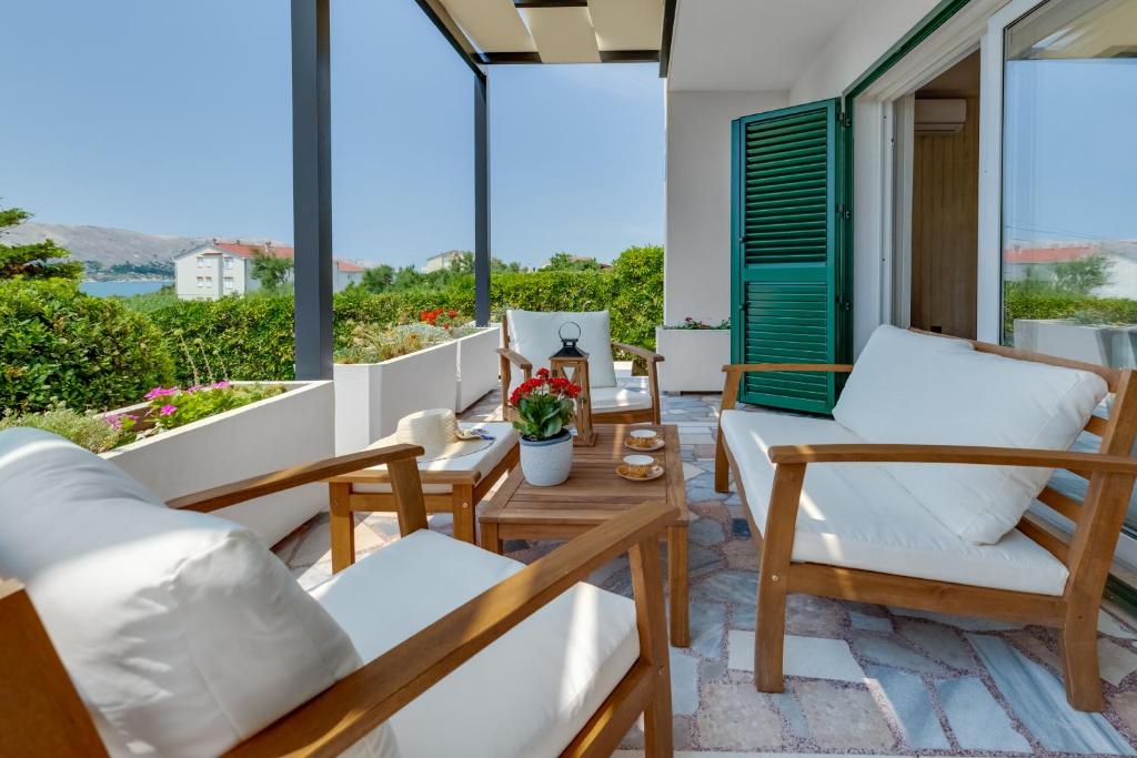 a balcony with white furniture and a view of the ocean at Villa Silencia in Pag