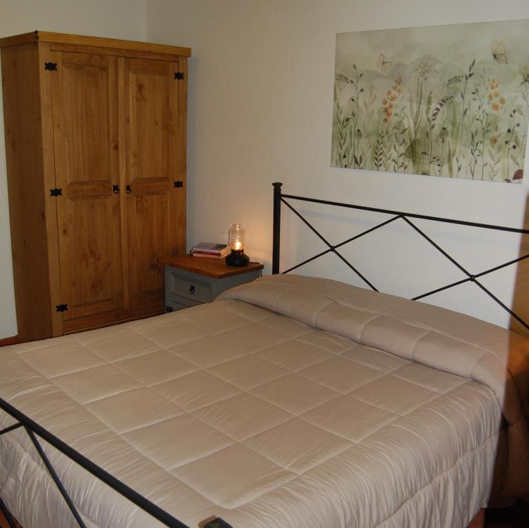 una camera da letto con un letto e un dipinto sul muro di La casa di Bacco - Etna Country House - Affitto breve a Castiglione di Sicilia
