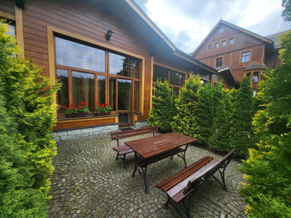 a patio with benches in front of a building at Apartament Józefina 8 dwupoziomowy z tarasem in Szklarska Poręba