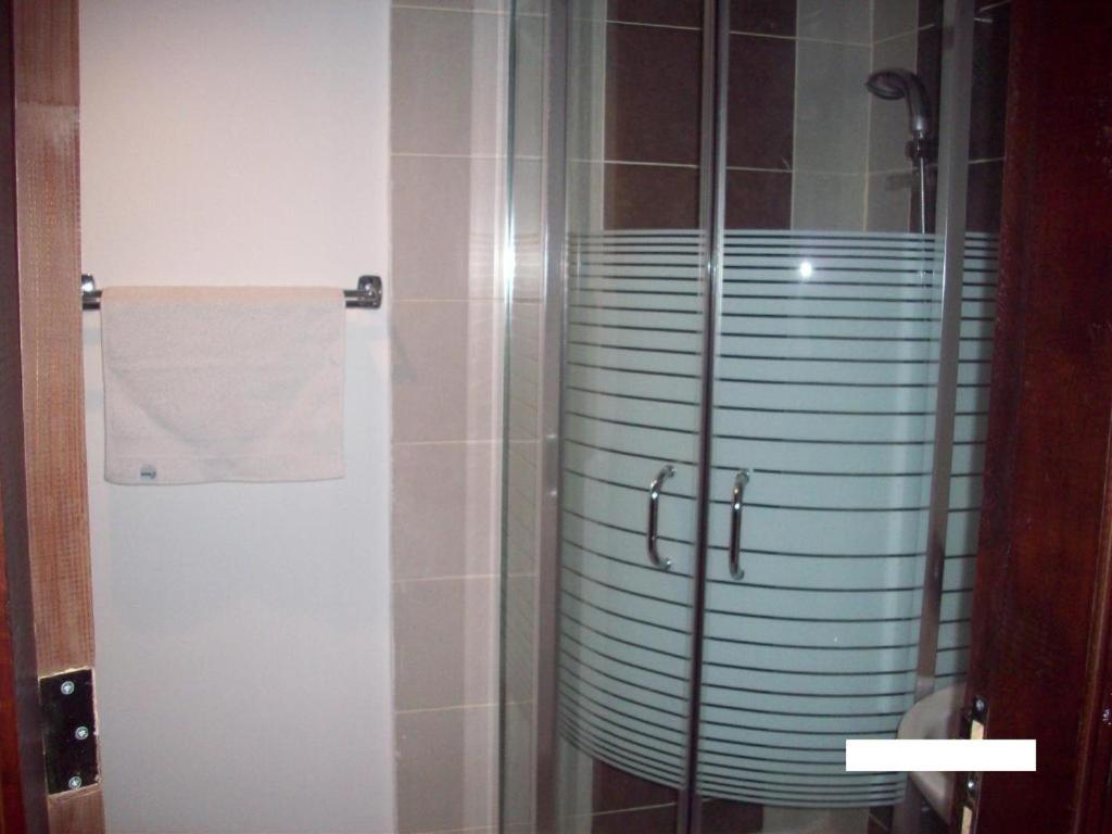 y baño con ducha y puerta de cristal. en Omaima Hotel Apartments, en Amán