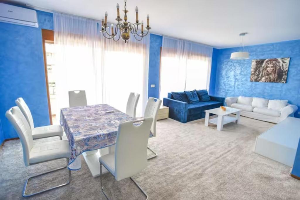 Redondo Apartments Budva في بودفا: غرفة طعام وغرفة معيشة مع طاولة وكراسي
