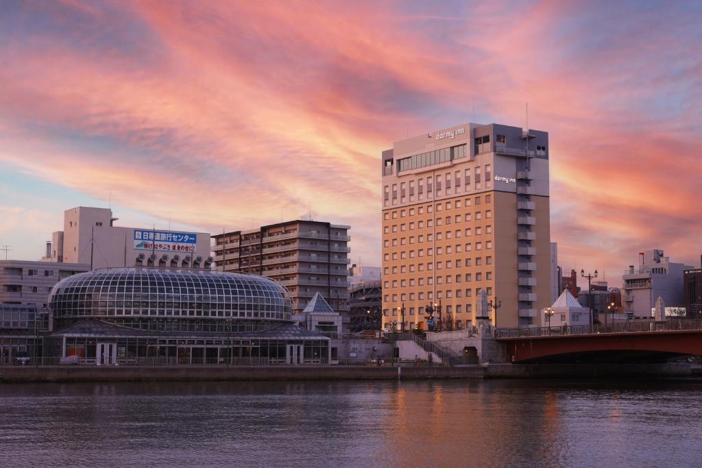 釧路的住宿－Dormy Inn PREMIUM Kushiro，城市天际线,有建筑和水面上的桥梁