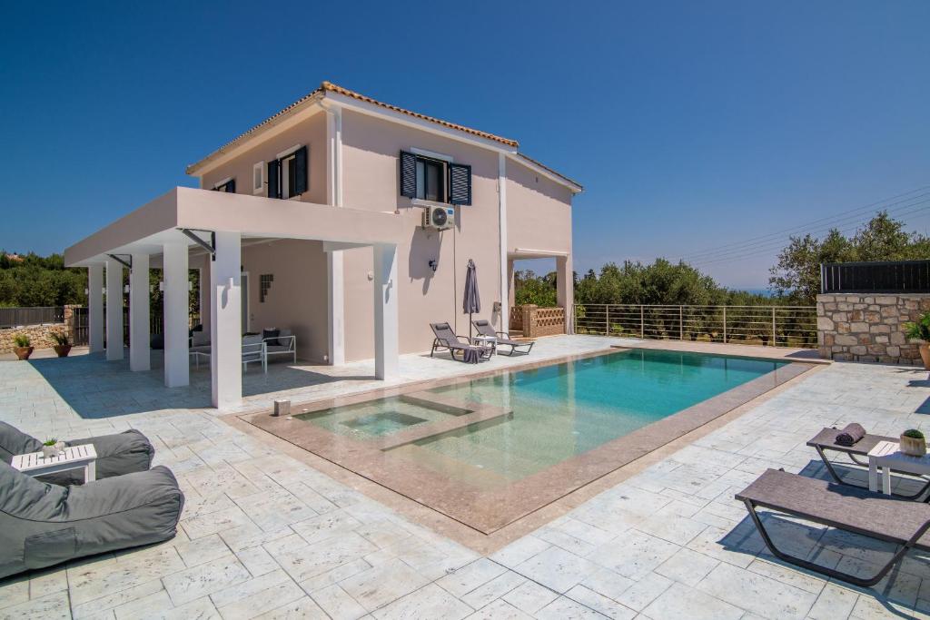 a villa with a swimming pool in front of a house at Le Mar Villa in Vasilikos