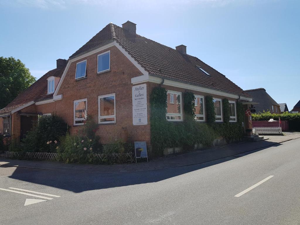 a brick house on the side of a street at Bed & Kitchen i Højer in Højer