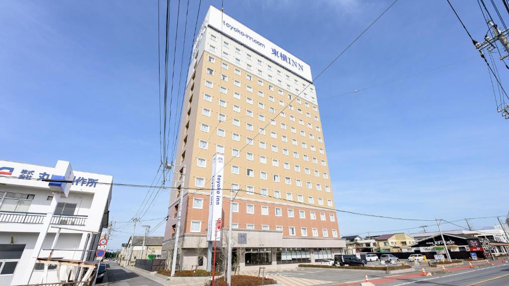 a tall building on the side of a street at Toyoko Inn Gumma Isesaki Ekimae in Isesaki