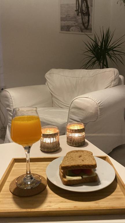 a tray with a sandwich and a glass of orange juice at Serenity Apart in Antalya