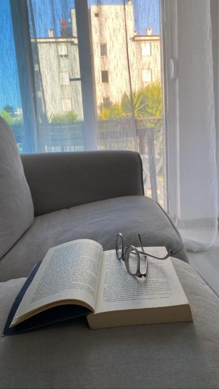 a book and glasses on a couch with a window at Serenity Apart in Antalya