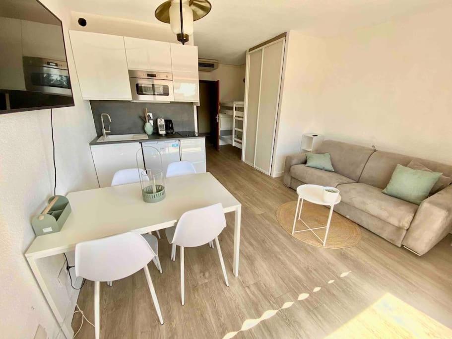 - un salon avec une table, des chaises et un canapé dans l'établissement Superbe studio avec terrasse - Port de Saint Laurent du Var, à Saint-Laurent-du-Var