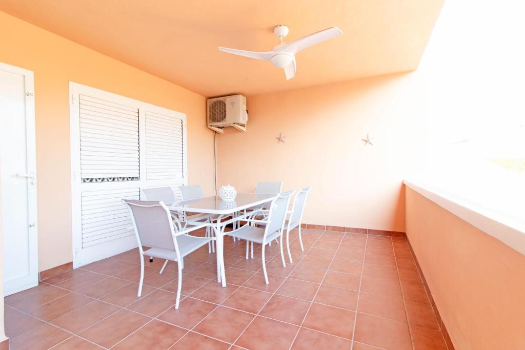 ein Esszimmer mit einem Tisch und Stühlen sowie einem Deckenventilator in der Unterkunft Global Properties, Acogedor adosado en la playa de Corinto in Sagunt