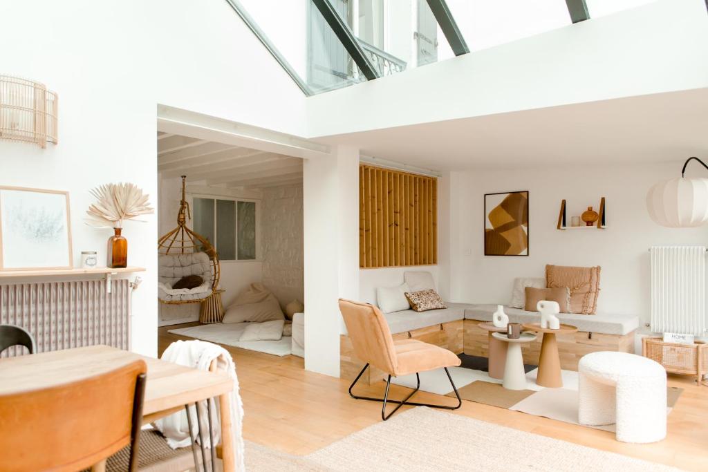 a living room with white furniture and a table at Logement entier ou à partager dans maison familiale à Rueil Malmaison, proche de Paris La Défense in Rueil-Malmaison