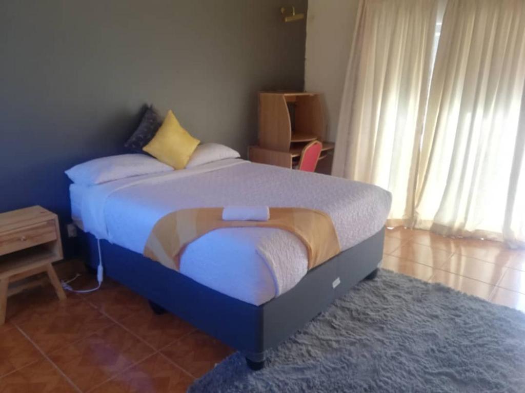 a bedroom with a bed in a room with a window at THE HAVEN GUEST HOUSE NKOYOYO in Mbabane