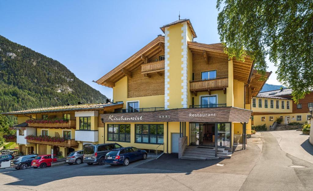 un edificio con coches estacionados frente a él en Landhotel Kirchenwirt en Unken