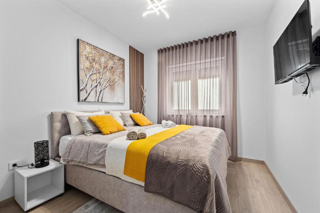 1 dormitorio con 1 cama grande con almohadas amarillas en Apartment Leone Medulin, en Medulin