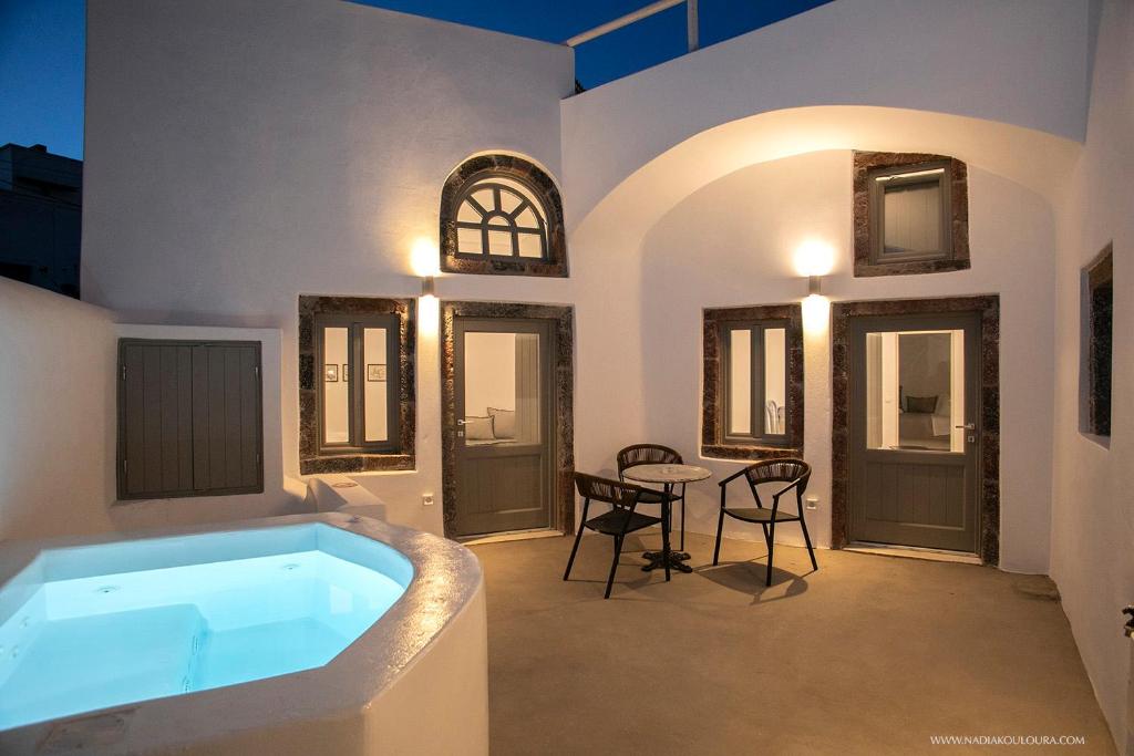 a large bathroom with a tub with a table and chairs at AnnaFani Villa in Pyrgos