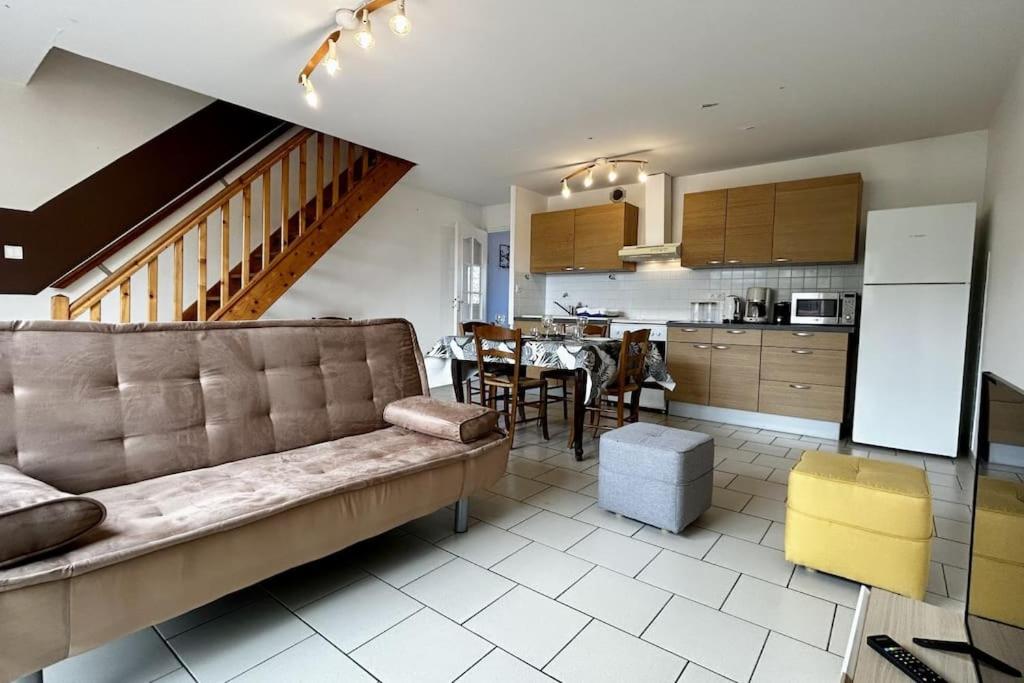 un salon avec un canapé et une cuisine dans l'établissement Mayocq 1, charmante maison avec jardin, au Crotoy