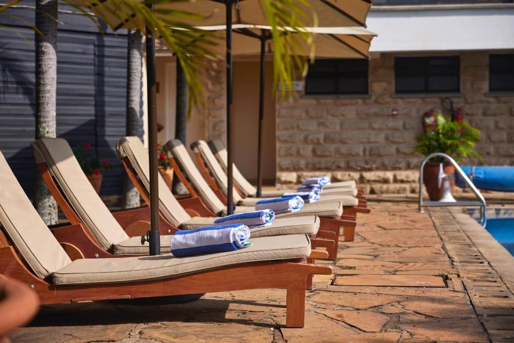 a row of lounge chairs lined up next to a pool at Aero Club of East Africa in Nairobi