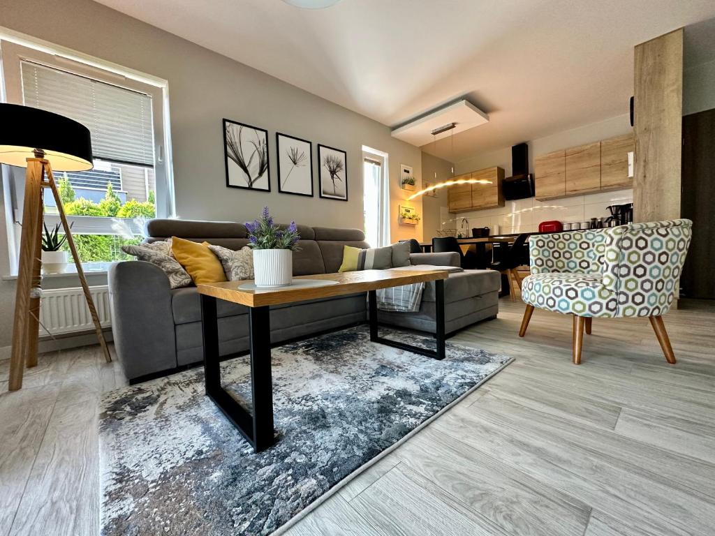 a living room with a couch and a table at Apartament Pogorzelica - Baltic Park in Pogorzelica