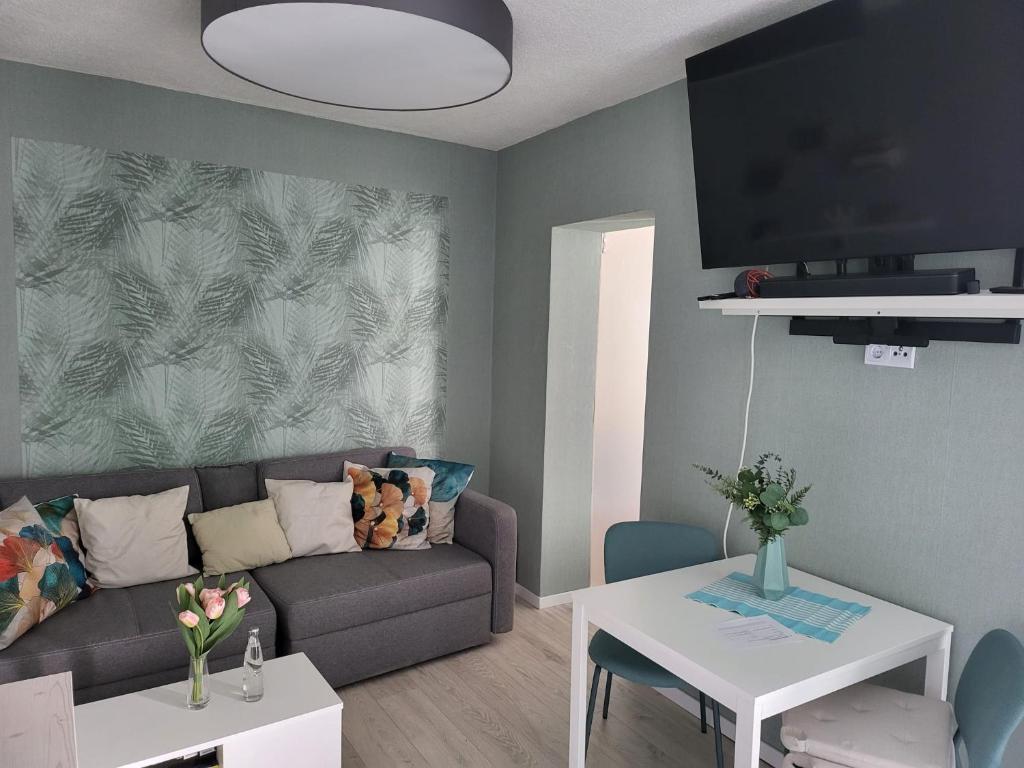 een woonkamer met een bank en een tafel bij Exquisite, gemütliche kleine Wohnung mit Balkon in Wolmirstedt