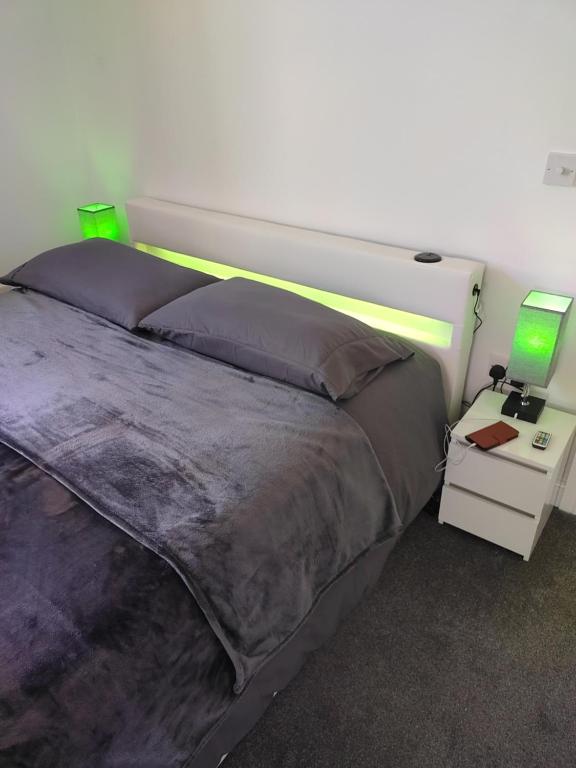 a bedroom with a bed and a night stand with a lamp at Top Quality Modern Southsea Garden Apartment Sleeps 4 People in Portsmouth