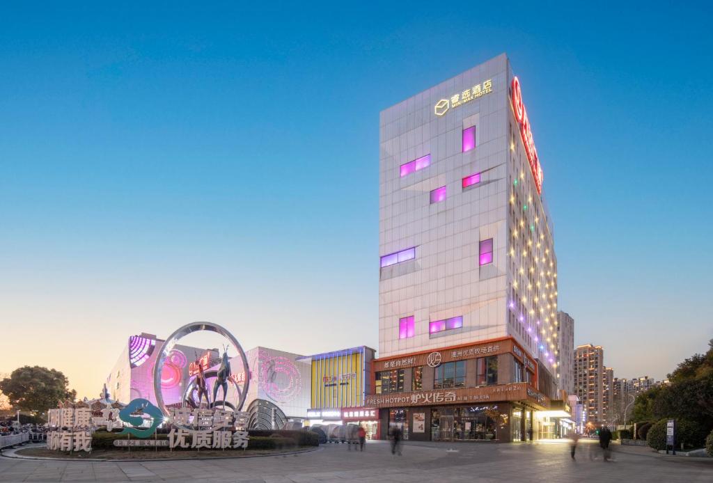 a tall building with a sign on the side of it at Minimax Hotel Shanghai Songjiang in Songjiang