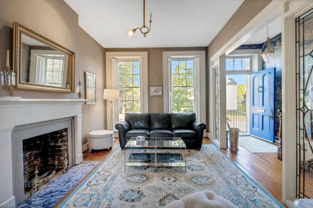 uma sala de estar com um sofá preto e uma lareira em Historic Petersburg Row Home em Petersburg