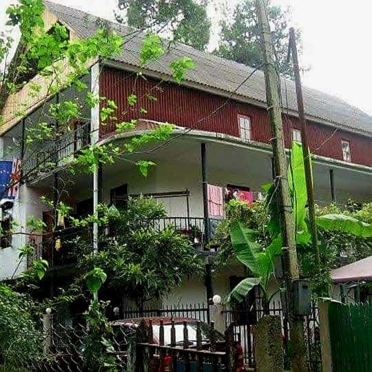 a red and white house with a balcony at Hostel Ureki Kidobani in Ureki